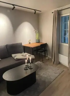 a living room with a couch and a table with candles at Newly renovated apartment in the middle of Trondheim city centre in Trondheim