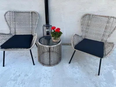 two chairs and a table with a plant on it at Comfort Apartment in Lone Only 20 minutes away from the heart of the city! in Bergen