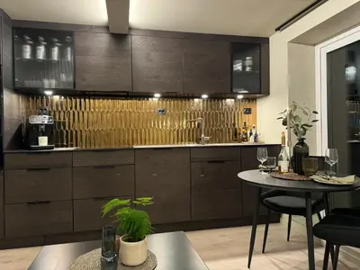 a kitchen with brown cabinets and a table with chairs at Comfort Apartment in Lone Only 20 minutes away from the heart of the city! in Bergen