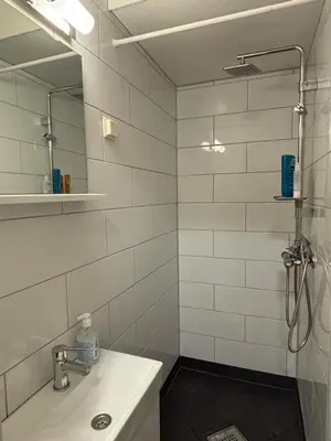 a bathroom with a sink and a shower with a mirror at Ski VM 2025 in Trondheim