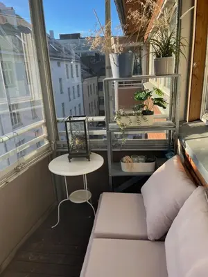 a balcony with a couch and a table and a window at Top floor, cozy apartment, centrally located in Trondheim in Trondheim
