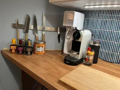a kitchen counter top with a coffee maker and utensils at Top floor, cozy apartment, centrally located in Trondheim in Trondheim