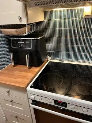 a kitchen with a stove and a microwave at Top floor, cozy apartment, centrally located in Trondheim in Trondheim
