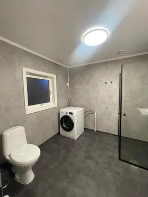 a bathroom with a toilet and a washing machine at Newly renovated apartment for rent in Stjoerdal