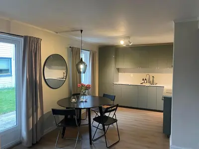 a kitchen and dining room with a table and chairs at Newly renovated apartment for rent in Stjoerdal