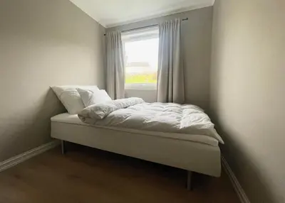 a small bed in a room with a window at Newly renovated apartment for rent in Stjoerdal