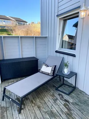 a bench and a table on a porch at Newly renovated apartment for rent in Stjoerdal