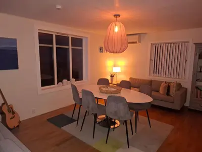 a living room with a table and chairs and a guitar at Close to the Airport and Trondheim in Malvik