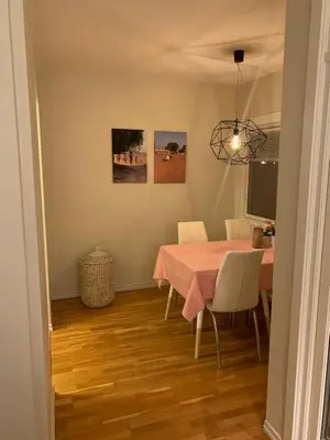 a dining room with a pink table and chairs at 2 bedrooms apartment in Trondheim