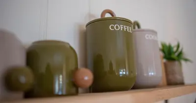 a shelf with three green canisters on it at Alpinlandsbyen - Ski in - Ski out -Nr 34 in Hafjell