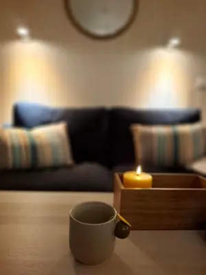 a cup of coffee on a table with a candle at Alpinlandsbyen - Ski in - Ski out -Nr 34 in Hafjell