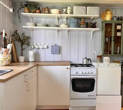 a kitchen with a stove and white cabinets at Veslekoia - Grandmas Cabin in Øksna