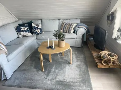 a living room with a couch and a table at Sjøro in Forland