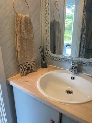 a bathroom counter with a sink and a mirror at Sjøro in Forland