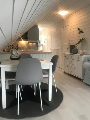 a kitchen with a white table and chairs at Sjøro in Forland