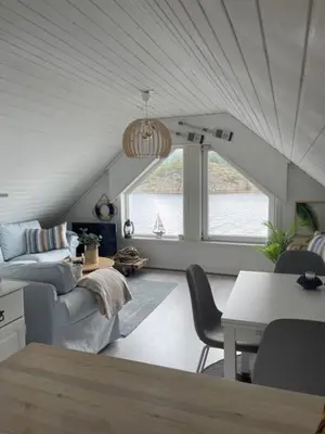 a living room with a couch and a table at Sjøro in Forland