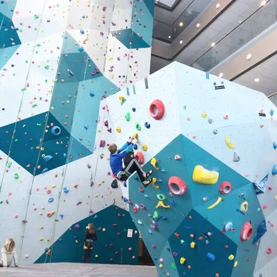 a man on a climbing wall in an indoor climbing gym at Cozy ski in & out apartment in Kyrkjebøen