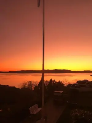 a sunset view of a body of water at Loft apartment in Bergen, Sandviken in Bergen