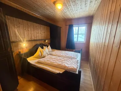 a bedroom with a bed in a wooden wall at Beitotind 1504 in Beitostøl