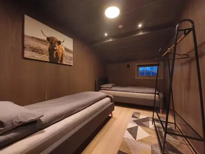 a bedroom with two beds and a poster of a cow at Hytte-13 Cozy cabin close to Kvitfjell in Fåvang