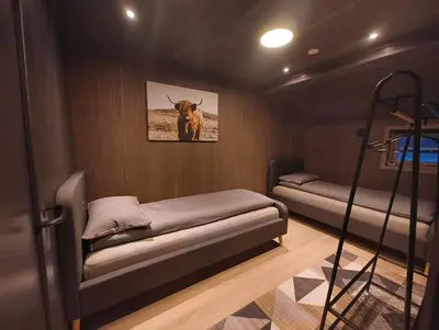 a room with two beds and a picture of a cow at Hytte-13 Cozy cabin close to Kvitfjell in Fåvang
