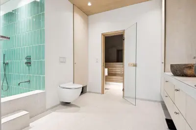 a bathroom with a toilet and a glass shower at Sjarmerende leilighet med utsikt, spa-bad og park in Bergen