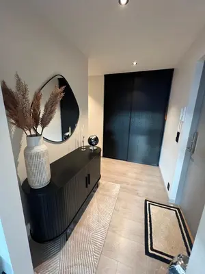 a hallway with a large mirror and a black dresser at Leilighet i trondheim in Trondheim