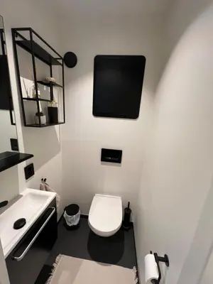 a bathroom with a toilet and a tv on the wall at Leilighet i trondheim in Trondheim