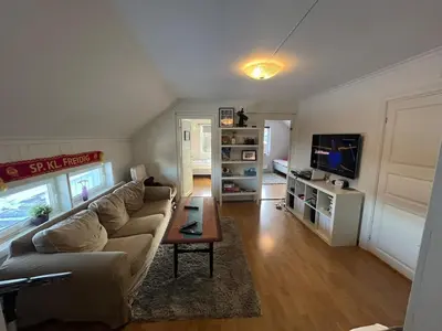 a living room with a couch and a tv at Older Villa with large garden in Trondheim
