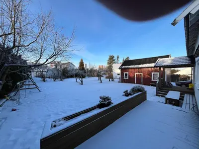 a yard covered in snow with a house at Older Villa with large garden in Trondheim