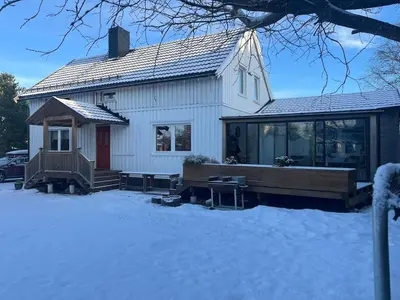 a house with a deck in the snow at Older Villa with large garden in Trondheim