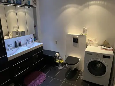 a bathroom with a sink and a washing machine at Older Villa with large garden in Trondheim