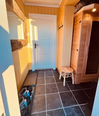 a small hallway with a door and a stool at Cozy cabin apartment, ski-in ski-out at Kvitfjell in Kvitfjell