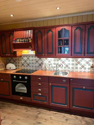 a kitchen with wooden cabinets and a stove and a sink at Cozy cabin apartment, ski-in ski-out at Kvitfjell in Kvitfjell