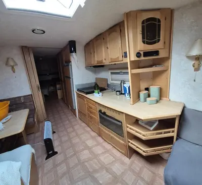 a small kitchen with wooden cabinets in a room at Trysil Campingvogn Ski in-out in Trysil