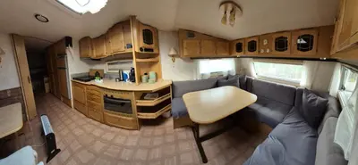 an interior of an rv with a table and a kitchen at Trysil Campingvogn Ski in-out in Trysil