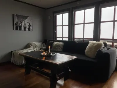 a living room with a couch and a coffee table at Cozy Top-Floor Apartment With Fireplace And Sauna in Beitostøl