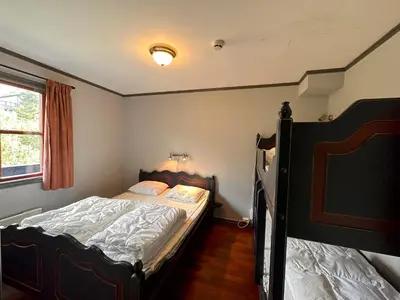 a small bedroom with a bed and a window at Cozy Top-Floor Apartment With Fireplace And Sauna in Beitostøl