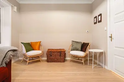 a room with two chairs and a bed and a door at DINBNB Homes l Charming 2-Bedroom Home by the Sea Cozy in Bergen