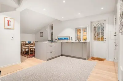 a kitchen with white cabinets and a dining room at DINBNB Homes l Charming 2-Bedroom Home by the Sea Cozy in Bergen