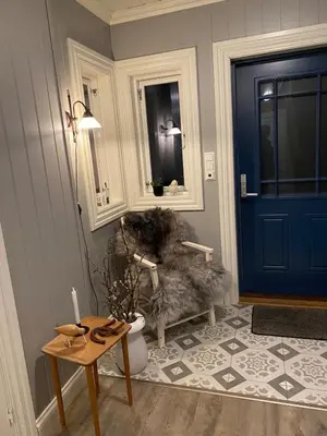 a hallway with a blue door and a table and a dog at Holiday house Vindafjord Norway in Ølsvågen
