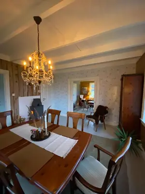 a dining room with a table and a chandelier at Holiday house Vindafjord Norway in Ølsvågen