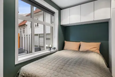 a bedroom with a bed and a large window at Modern Apartment in 1840-Building at Nordnes in Bergen