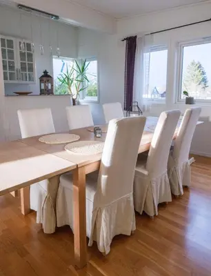 a dining room table with white chairs around it at Spacious house, close to Granåsen Ski Arena! 4 beds, 2 bathrooms, free parking in Trondheim