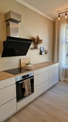 a kitchen with white cabinets and a stove top oven at Jugend City Retreat - Ålesund Apartment in Ålesund
