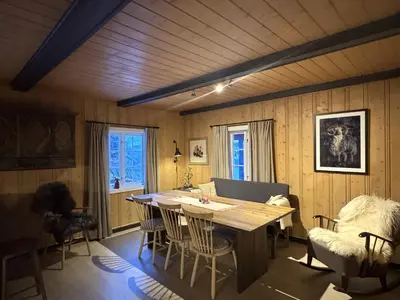 a dining room with a wooden table and chairs at Charming Cabin Near Hallingskarvet Ski Center, Cozy and Inviting! in Skoro