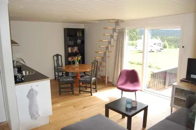 a kitchen and living room with a table and chairs at Apartment on Golsfjellet! in Gol