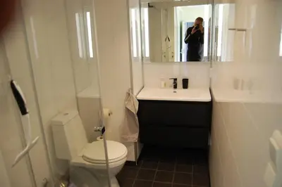 a person taking a picture of a bathroom with a toilet at Apartment on Golsfjellet! in Gol