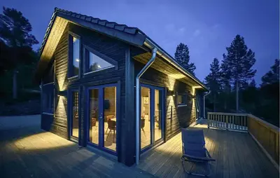 a house with a deck with a chair on it at 3 Bedroom Cozy Home In Rendalen in Rendalen