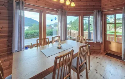 a dining room with a table and chairs and windows at Gorgeous Home In Eivindvik With Wifi in Eivindvik
